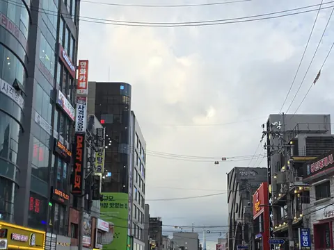 Signboards along a street in the Hongdae area under an overcast sky